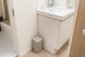 洗面台横の邪魔にならない位置に小さなゴミ箱を置いた洗面所