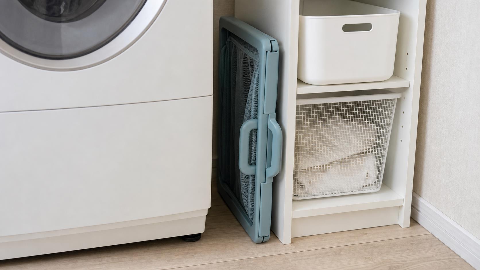 運搬用の洗濯かごを畳んで洗濯機横の隙間へ戻した状態