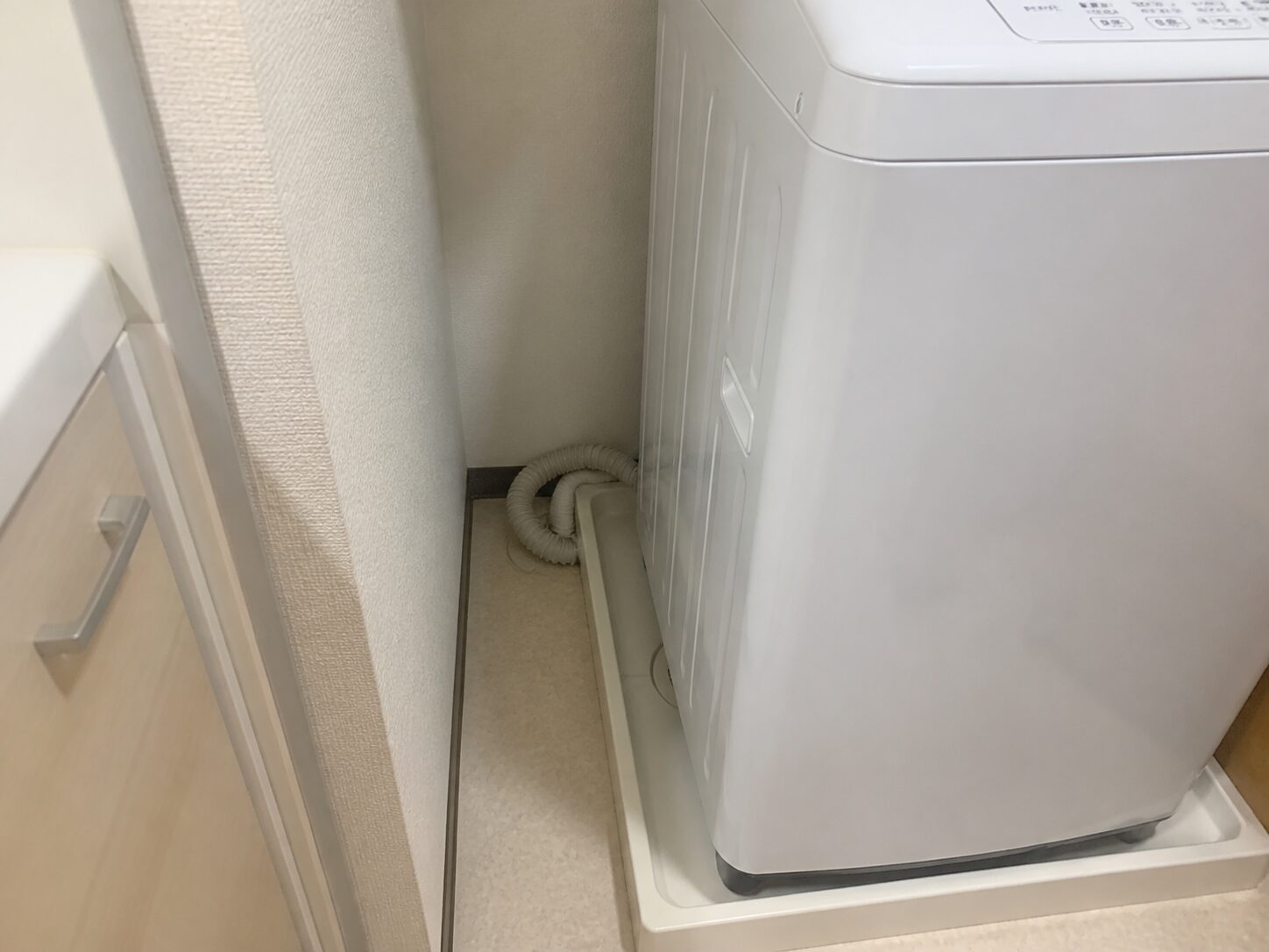 洗濯機横のすき間に排水ホースが見えている状態