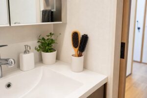 洗面所の鏡横でヘアブラシを立てて乾かす収納