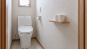 狭いトイレの壁面棚に交換用トイレットペーパーを置いた様子