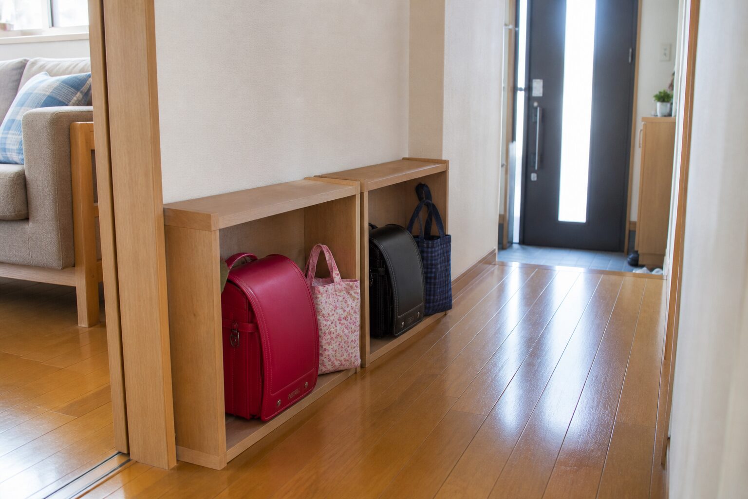 翌朝持ち出すランドセルと手提げを一人分ずつ壁際へまとめ通路を空けた場面
