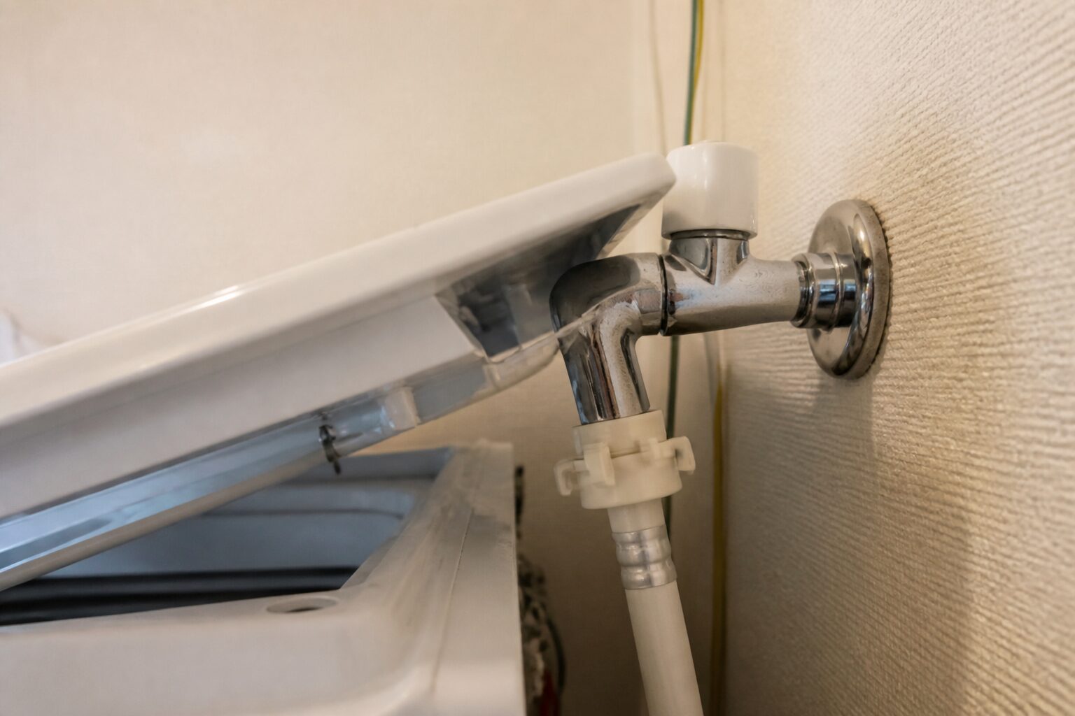 洗濯機のふたが蛇口と給水ホースの接続部に近づく衝突箇所
