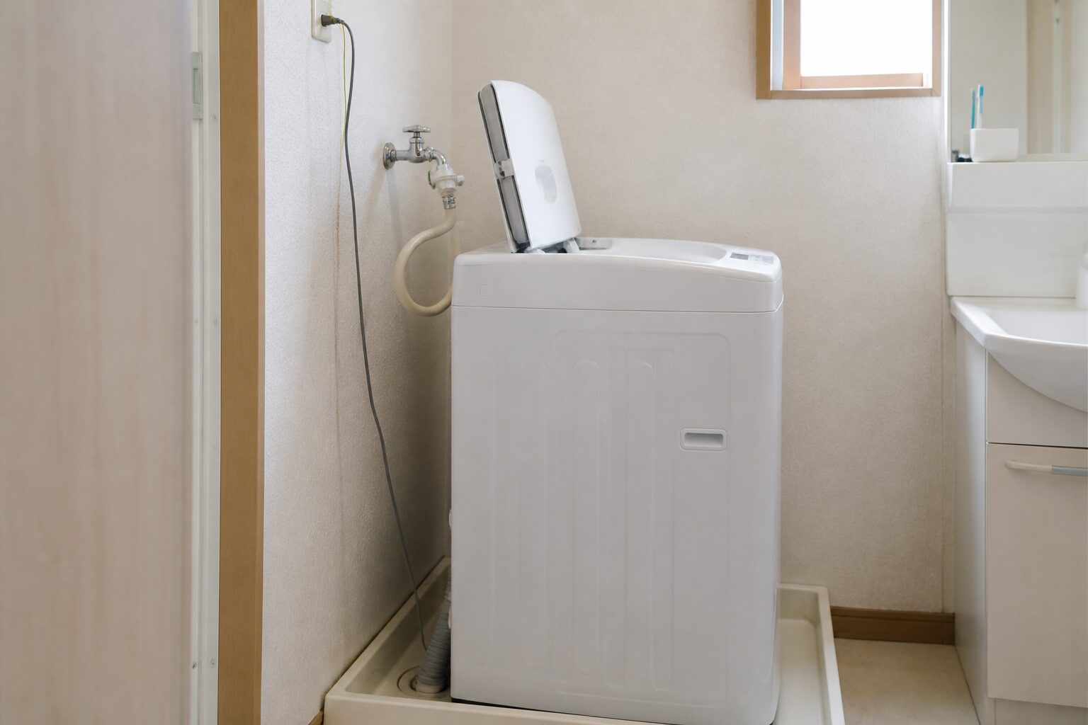 洗濯機を少し前へ置いてふたと蛇口の間に余白を作った様子