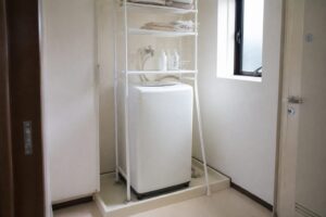 防水パンまわりに設置した白いランドリーラックと洗濯機