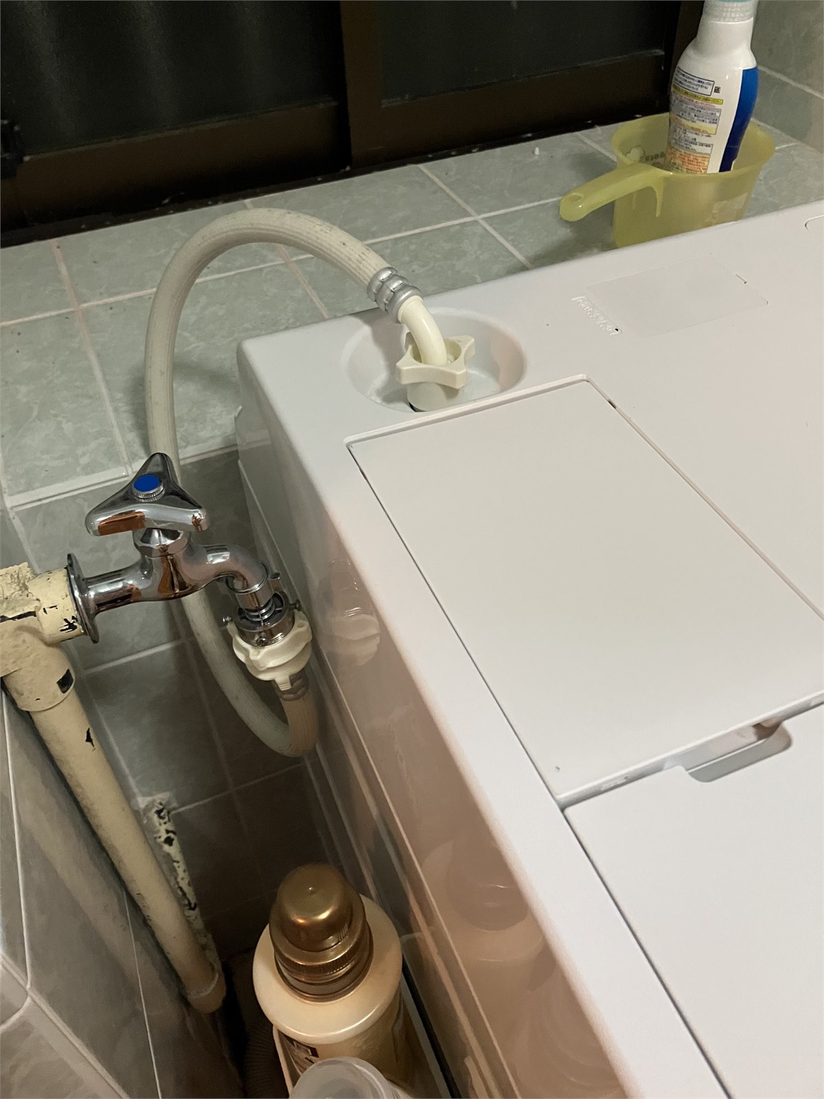 洗濯機上部のふた近くにある蛇口と給水ホース